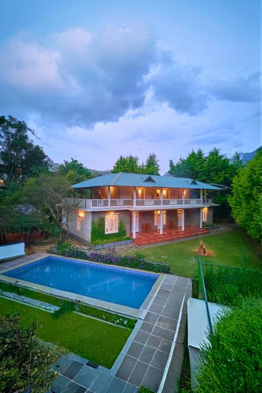 an aerial view of a house with a swimming pool at Ministers Mansion Kanthalloor Pool Resort by VOYE HOMES in Kanthalloor