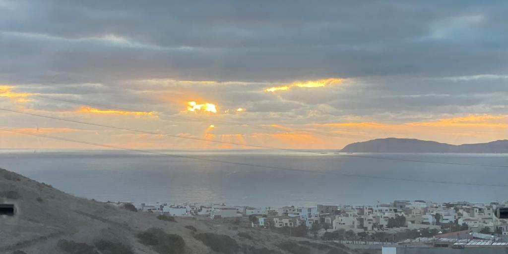 a view of a city and the ocean at sunset at Olas de San Marino in Harry Manzo