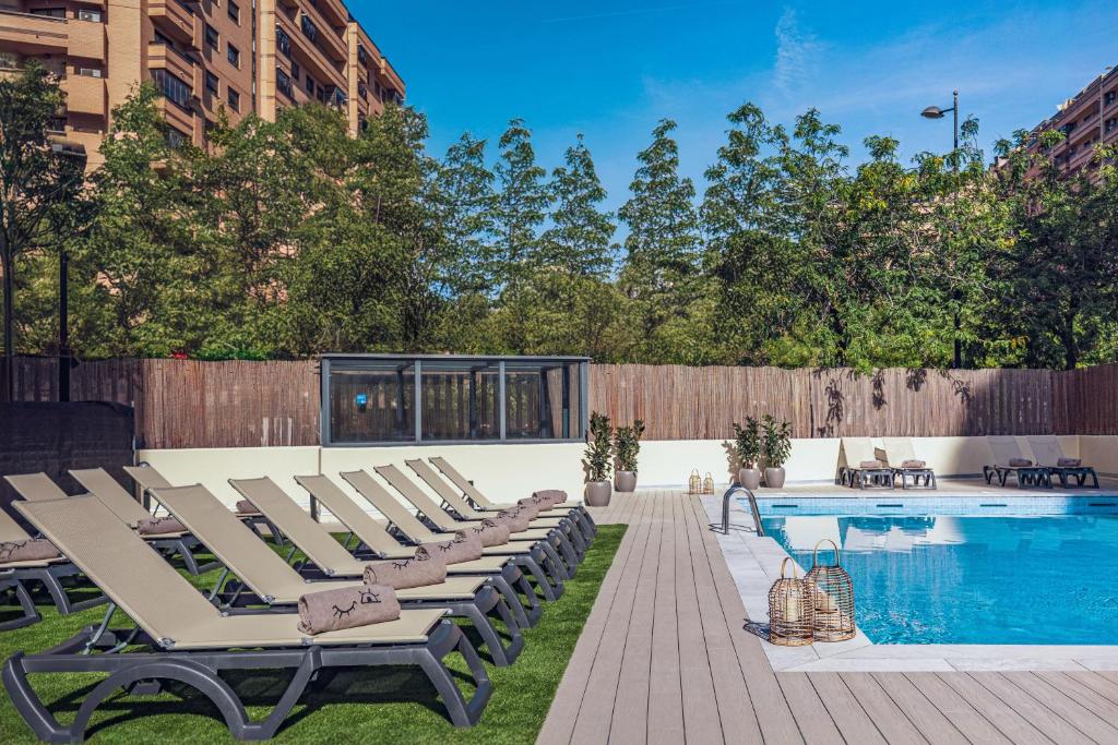 a row of lounge chairs next to a swimming pool at INNSiDE by Meliá Valencia Oceanic in Valencia