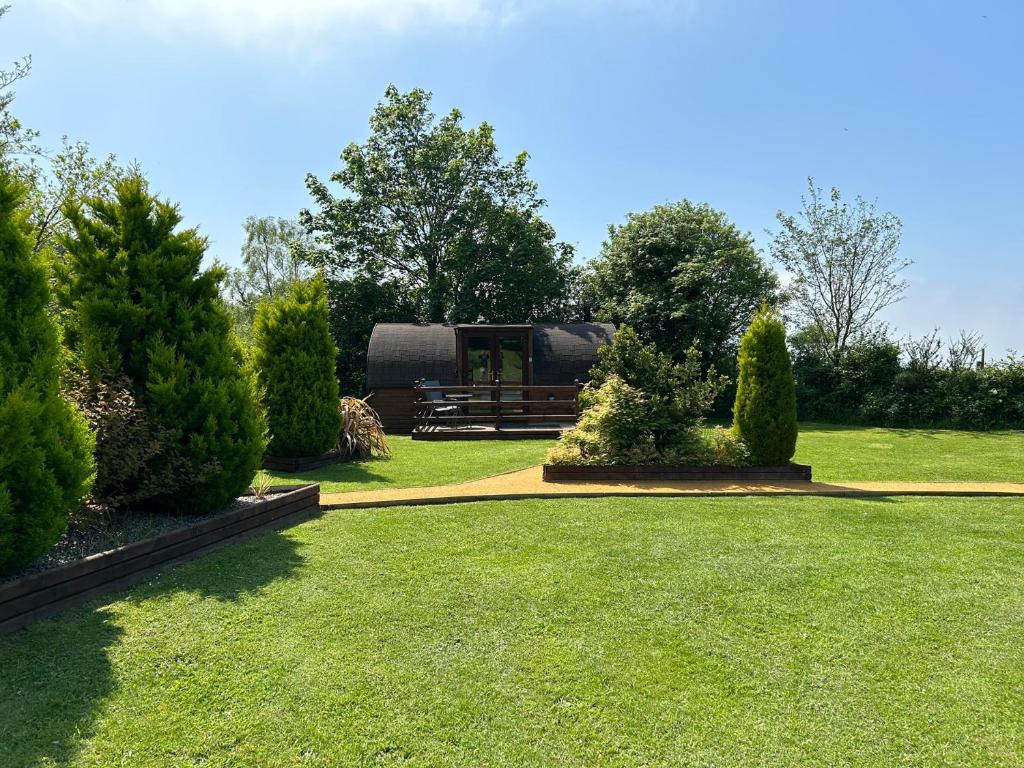 a view of a garden with a yurt in the background at Idris Pod in Tremeirchion
