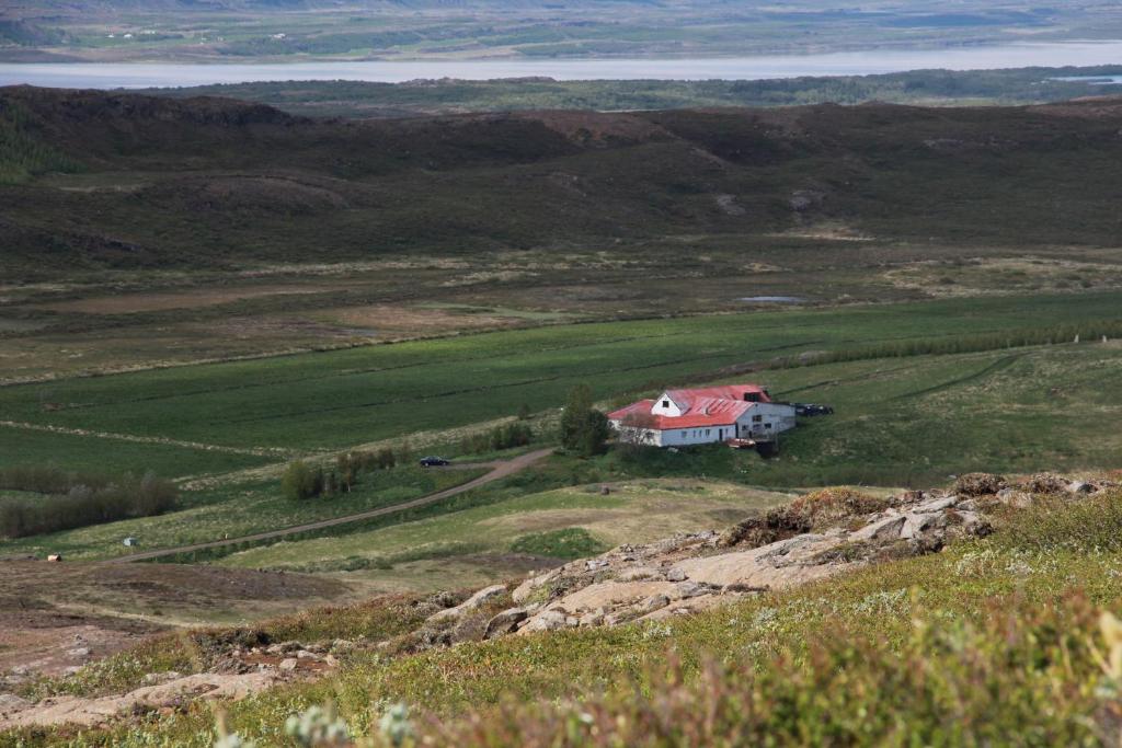 une maison assise au sommet d'une colline herbeuse dans l'établissement Country House Tokastaðir, à Egilsstaðir