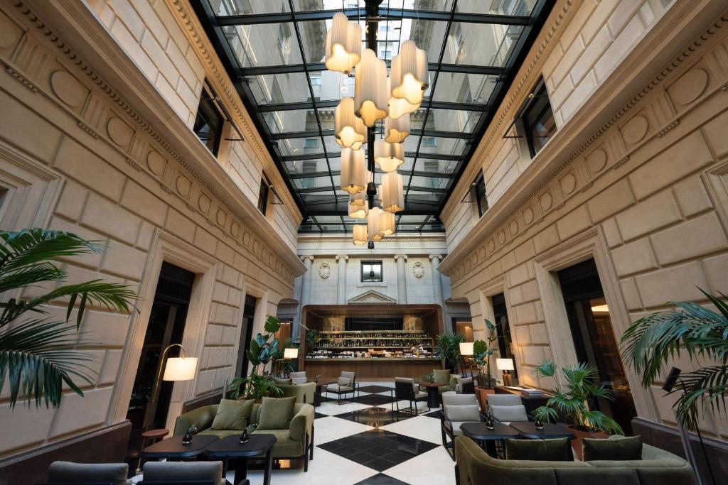 a lobby of a hotel with chairs and a piano at Casa Lucia member of Meliá Collection in Buenos Aires