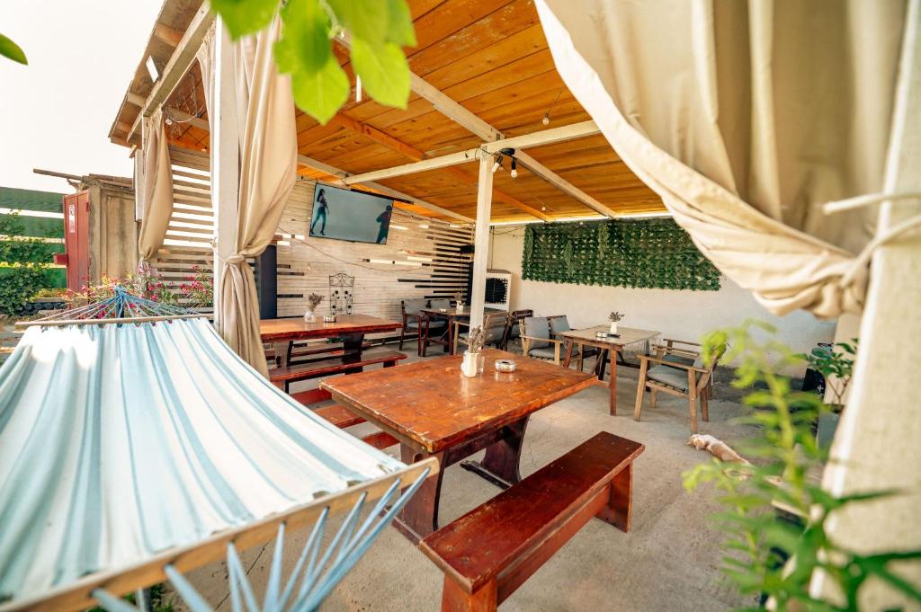 a patio with tables and chairs and a tv at Casa Dumitrescu in Năvodari