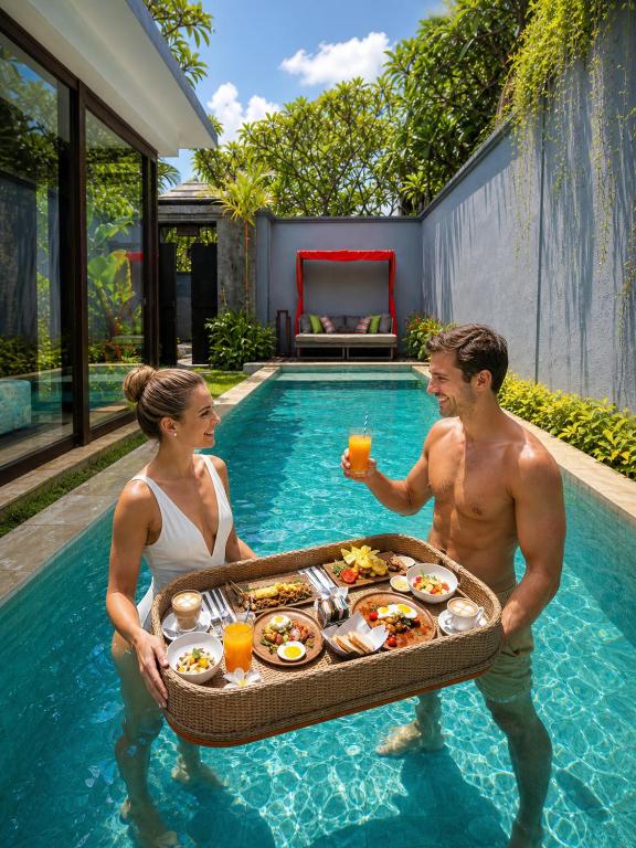 a man and woman holding a tray of food in a swimming pool at Seminyak Icon - by Karaniya Experience - CHSE certified in Seminyak