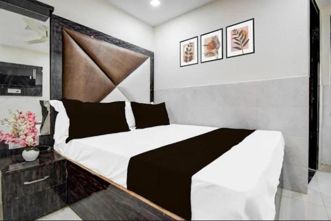 a bedroom with a large bed with black and white sheets at Hotel Birhana road in Kānpur