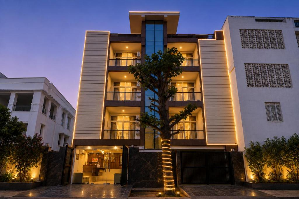 a building with a palm tree in front of it at Hotel Smart Snap Sector 104, Noida in Noida