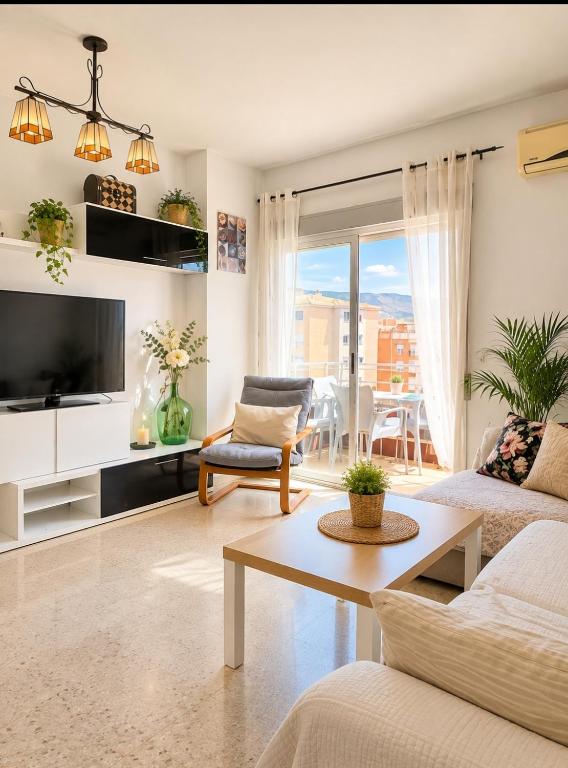 a living room with a couch and a tv at Disfruta Granada, Parking y Mascotas in Granada