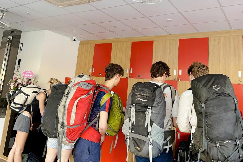 a group of people standing in a room with backpacks at Hanoi Capsule Station Hostel in Hanoi