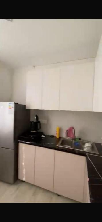 a kitchen with white cabinets and a sink and a refrigerator at Panoramic view in Tamga