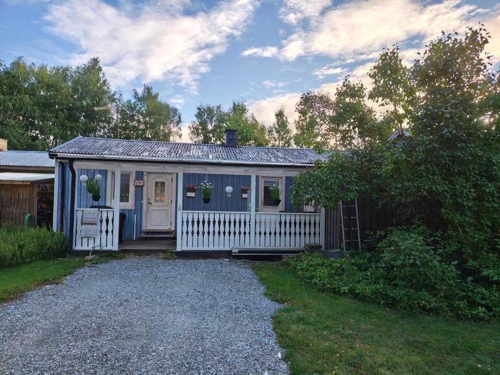 a small house with a white fence in a yard at Muminhuset i Norberg in Norberg