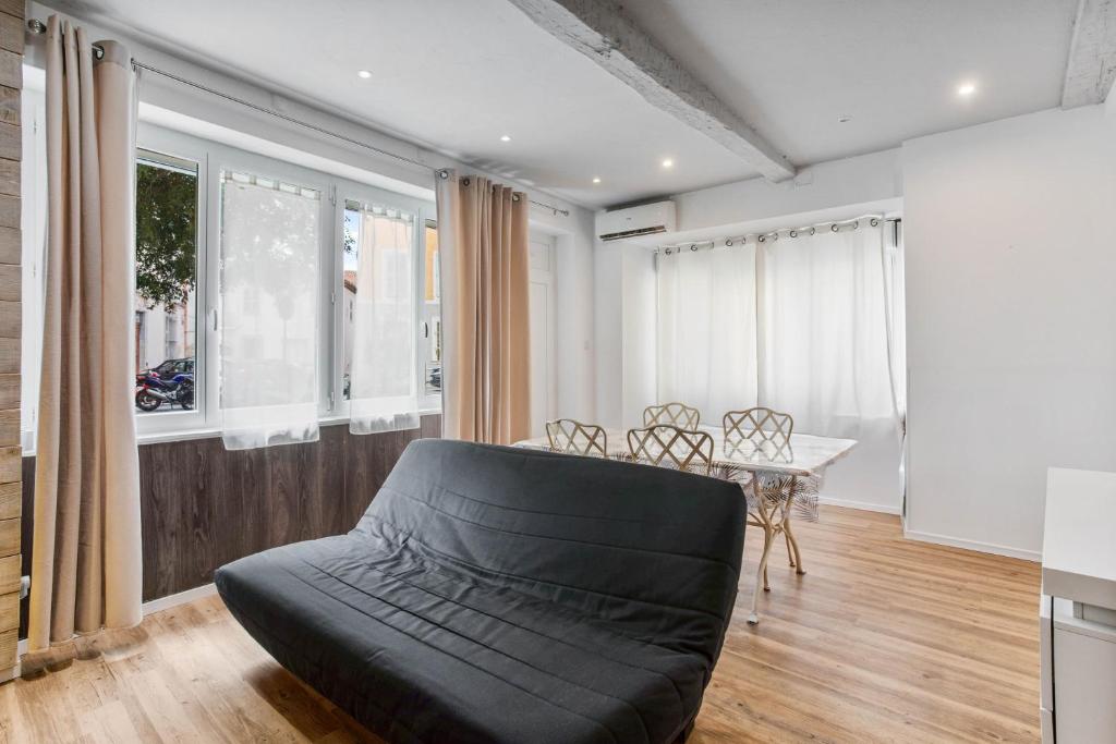 a living room with a couch and a table and windows at Le Loft 11 Draguignan in Draguignan