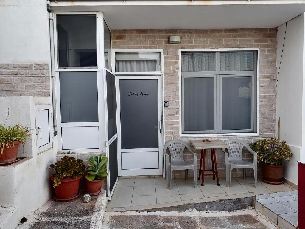 a patio with a table and chairs and a door at Sofia's House in Zekros