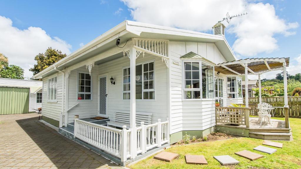 ein weißes Haus mit einer Veranda und einem Hof in der Unterkunft Charmae Guest House in Whanganui