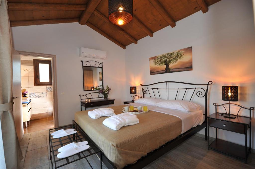 um quarto com uma cama grande e toalhas em Olivia Villas em Raches