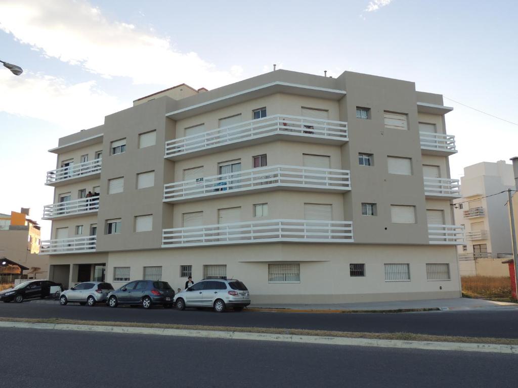 un gran edificio de apartamentos con coches aparcados frente a él en Departamento Bellavista Frente al Mar en Miramar