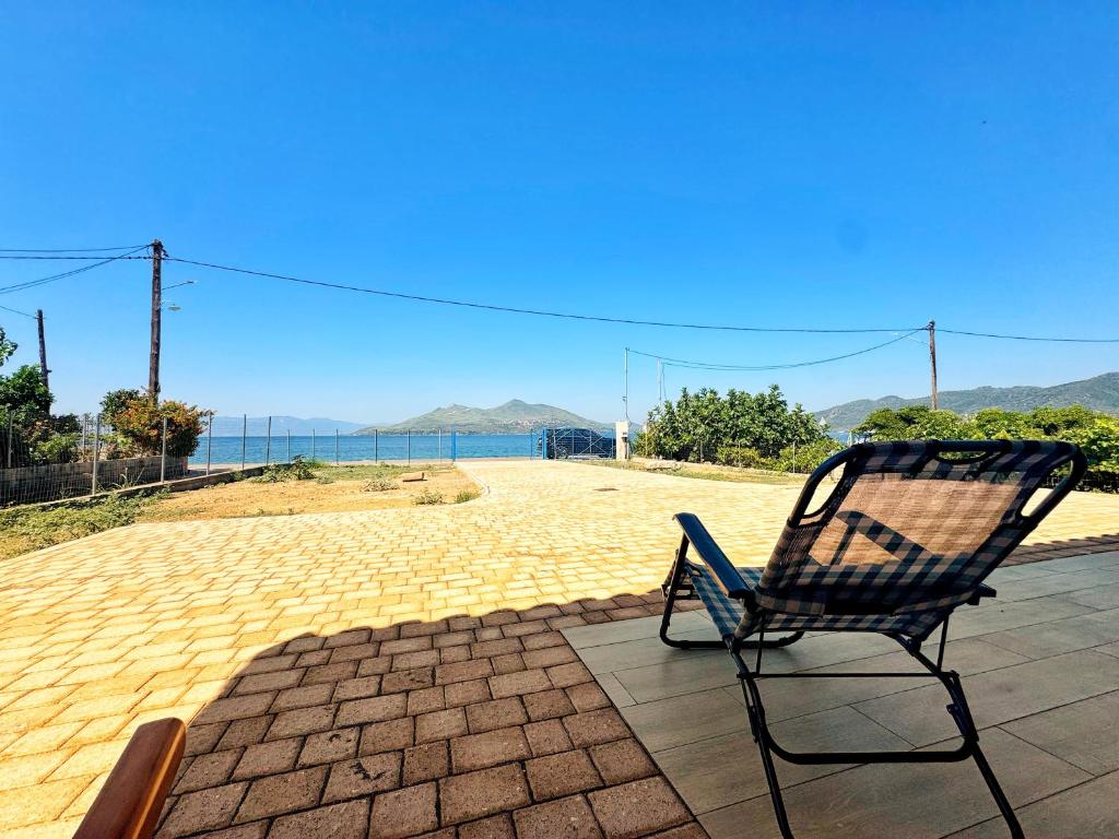 a chair sitting on a patio with a view of the ocean at Maria's Seafront Villa in Loutra Edipsou