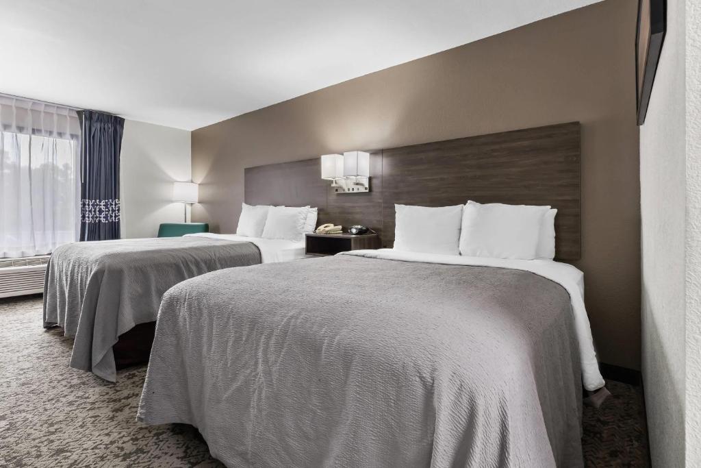 a hotel room with two beds with white sheets at Quality Inn Kinston Hwy 70 in Kinston