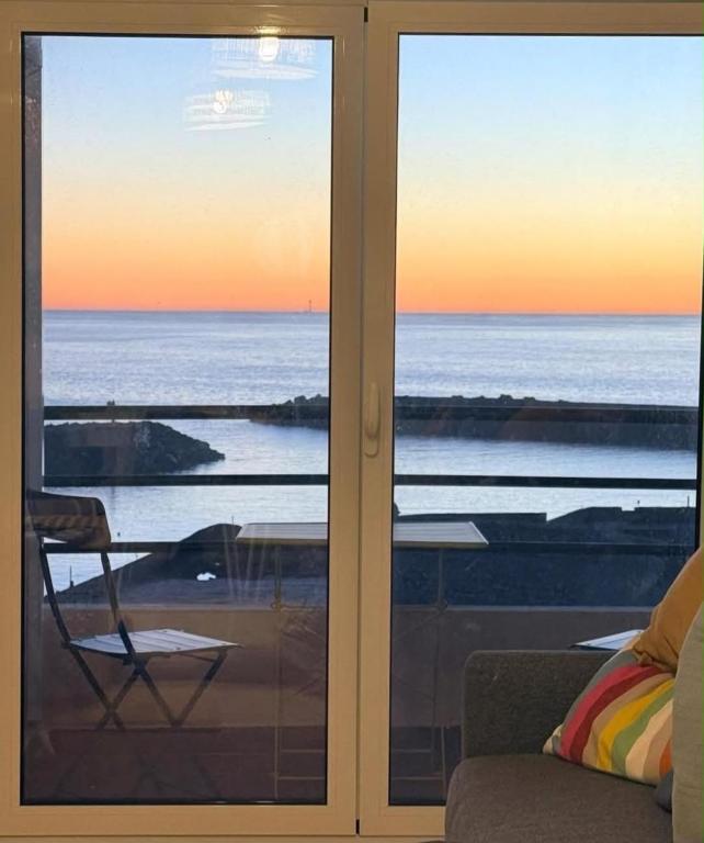 a glass door with a view of the ocean at Três Sardinhas in Vila Praia de Âncora