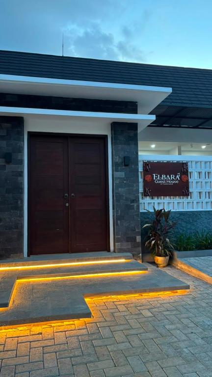 a building with a large brown door in front at Elbara Guest House Syariah in Banjarbaru