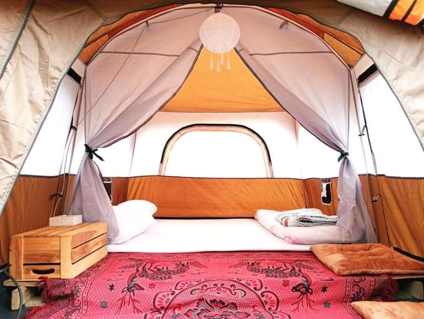 a bed in the front of a tent at กลางขุนเขา klang khun khao in Ban Na Yang
