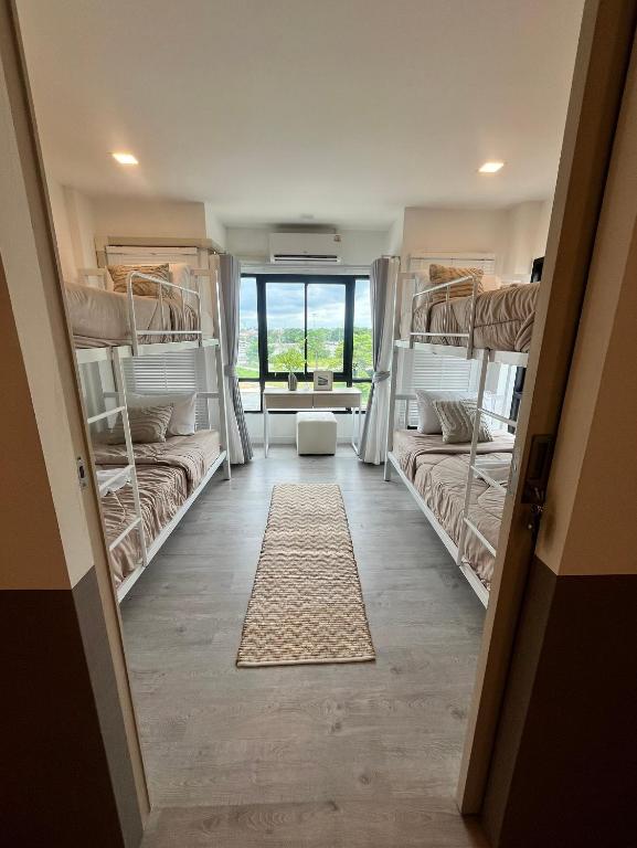 a room with four bunk beds and a hallway at The Eiffel Cafe and Hotel in Ban Khlong Lat Bua Khao