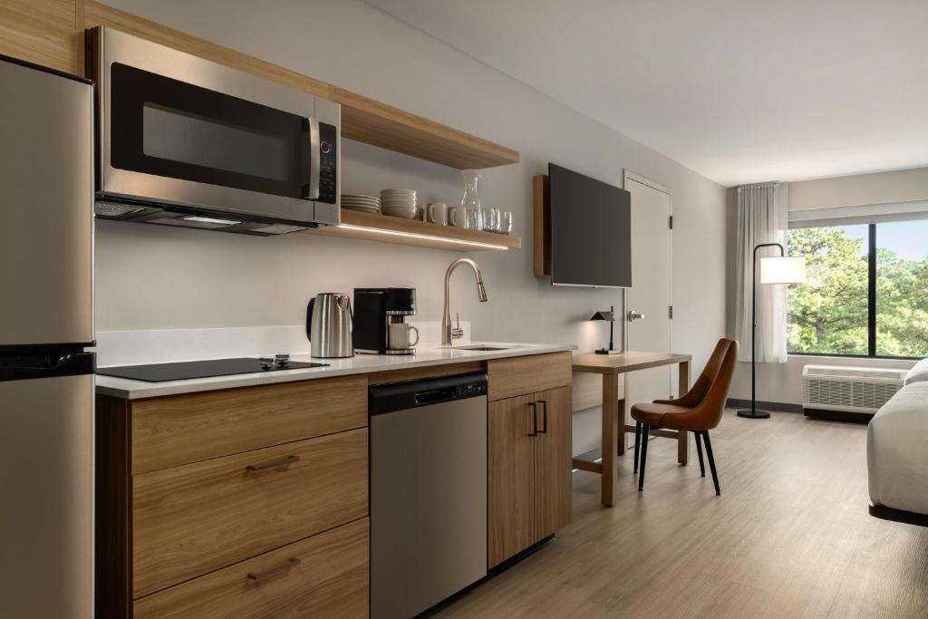 a kitchen with a sink and a stove top oven at Hyatt Studios Chesapeake in Chesapeake