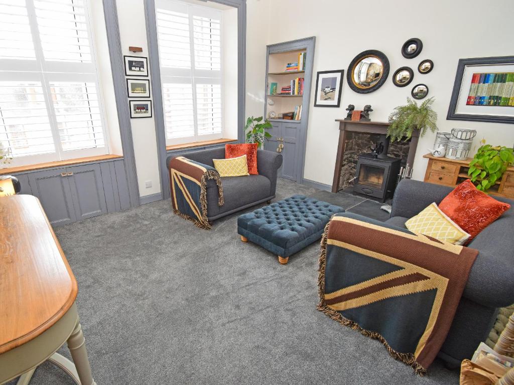 a living room with a couch and chairs and a fireplace at The Beltie Flat in Newton Stewart