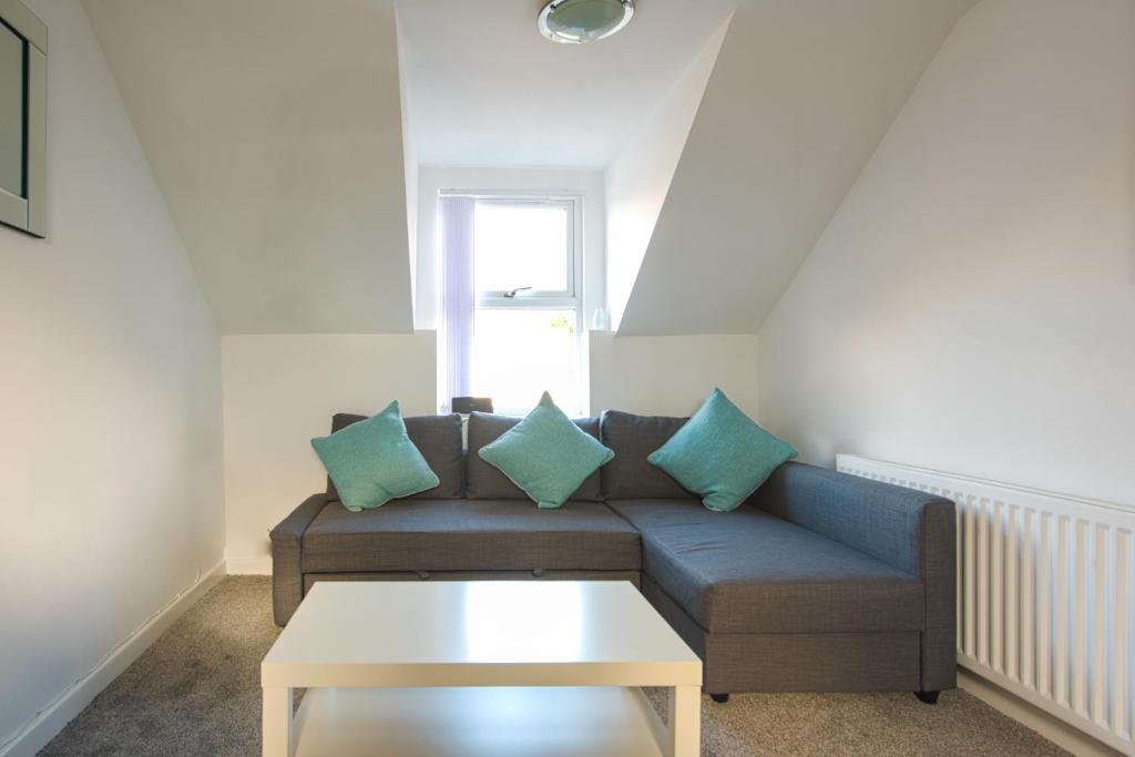 a living room with a couch and a table at Crosshills Serviced Apartments in Leeds