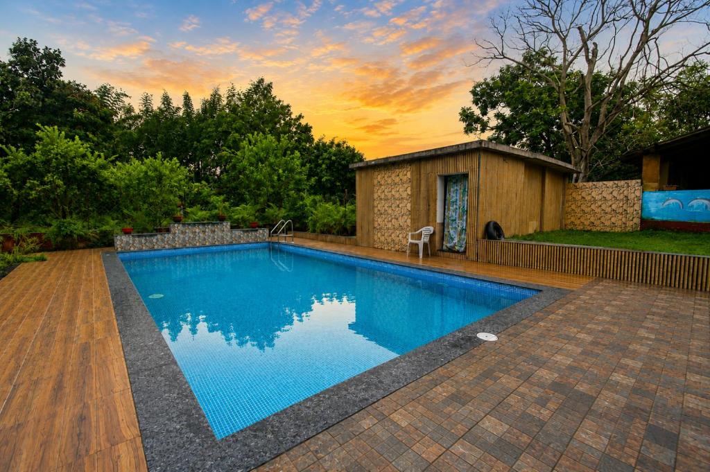 a swimming pool in a yard with a house at Tribal Wood Resort in Dhanwār