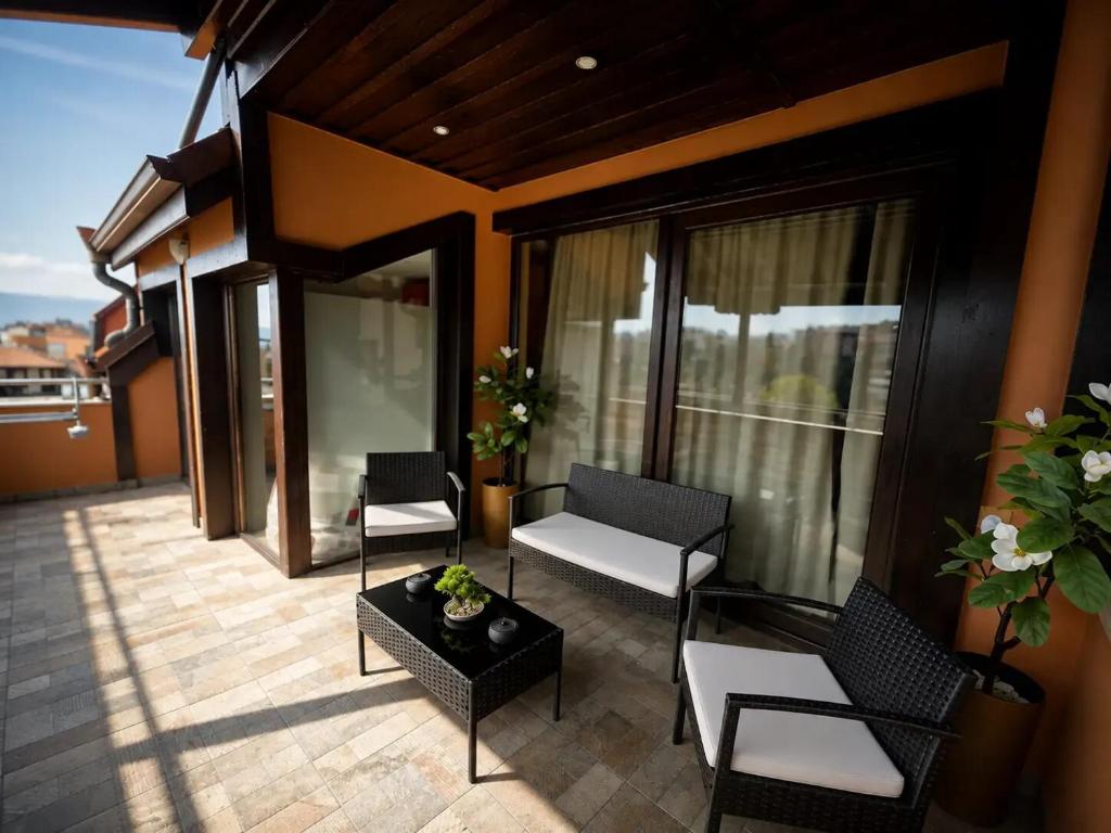a living room with chairs and a table on a balcony at Medius Park Apartment in Sandanski