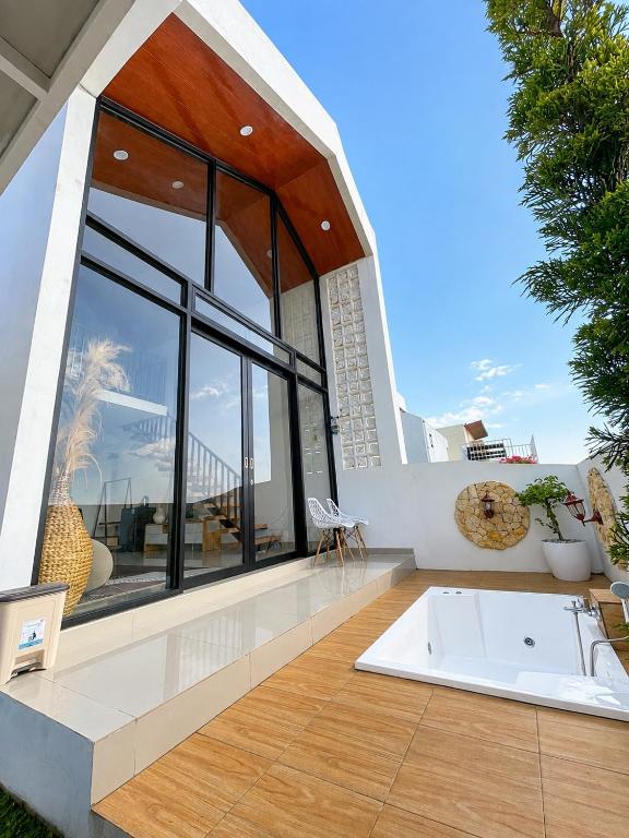 a bath tub sitting on the deck of a house at Villa With Jacuzzi, Damar Ningrum 3 in Tutugan