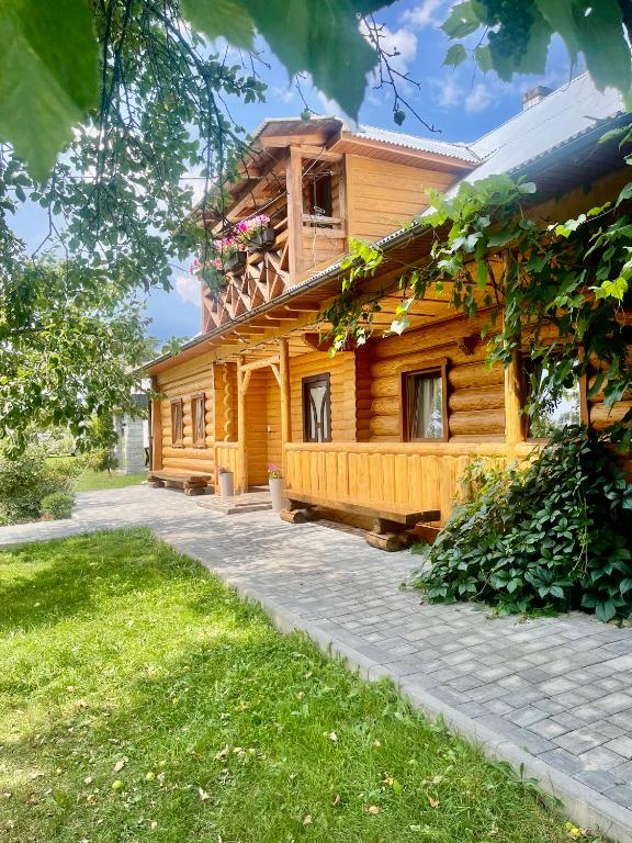 a wooden house with a pathway in front of it at «У полоні гір» in Verkhovyna