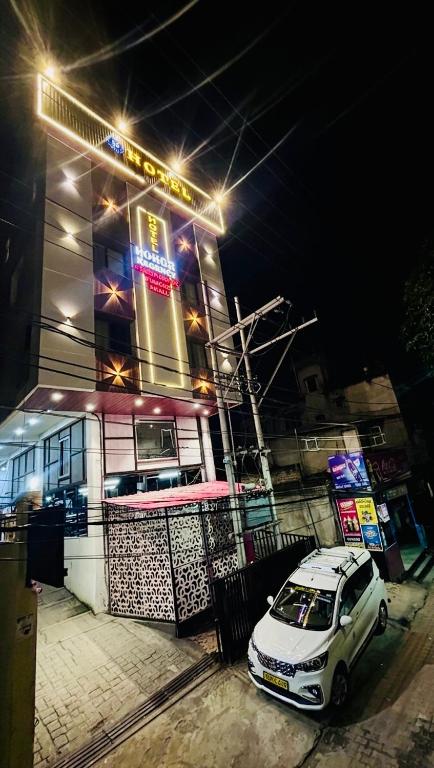a white car parked in front of a building at night at Hotel Pohor Regency 10 minutes travel to Kamakhya Temple in Guwahati