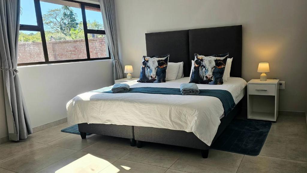 a bedroom with a large bed with blue pillows at Wave Dancer 2-Bedroom Apartment in St Lucia