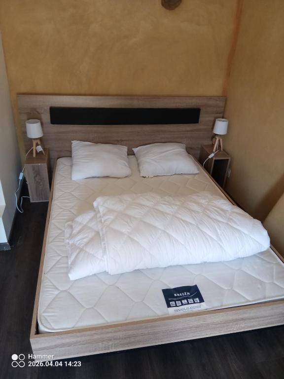 a bed with white sheets and pillows on it at house in Saint-André-des-Eaux