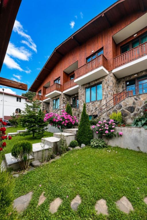 a building with a garden in front of it at Fortuna Cottage Bakuriani in Bakuriani