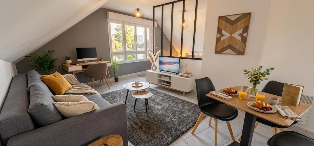 a living room with a couch and a table at Appart'Hôtel - Chateaubriant in Châteaubriant