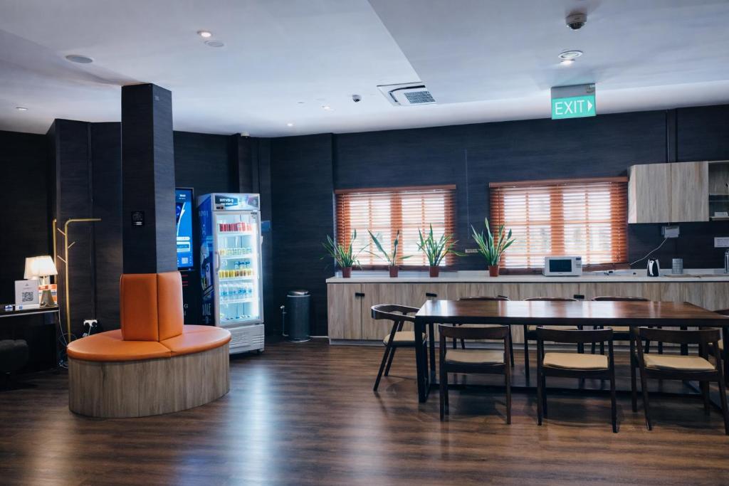 a dining room with a table and a refrigerator at A Hotel Bugis Village in Singapore