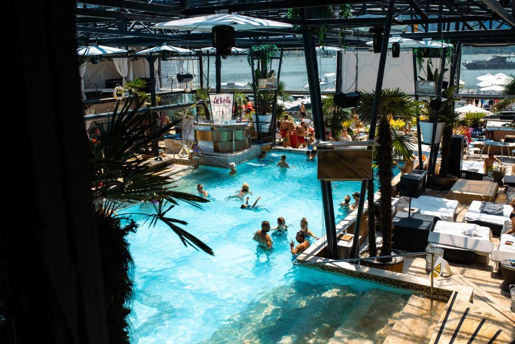 a group of people in a pool at a resort at La Vella Resort in Dubova