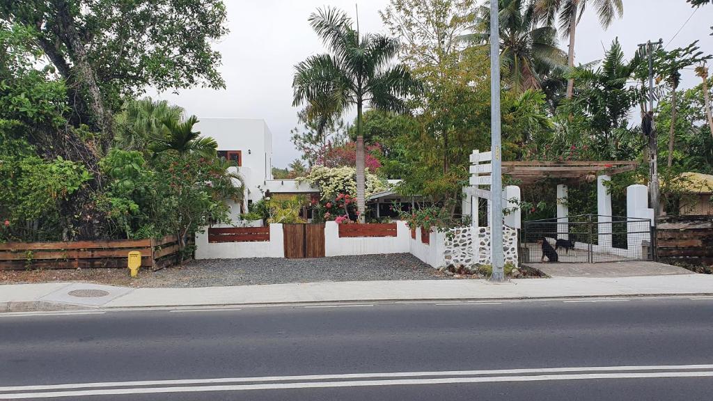 a street view of a house with a fence and trees at dilo tree lodge in Sigatoka