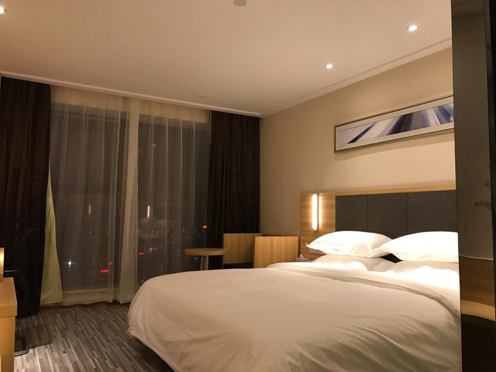 Postel nebo postele na pokoji v ubytování Hotel Pomelo Premier 西柚臻选武昌站酒店