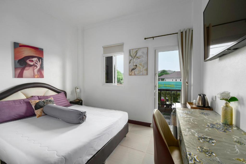 a bedroom with a bed and a dining table at Passion Nai Harn Guesthouse in Nai Harn Beach