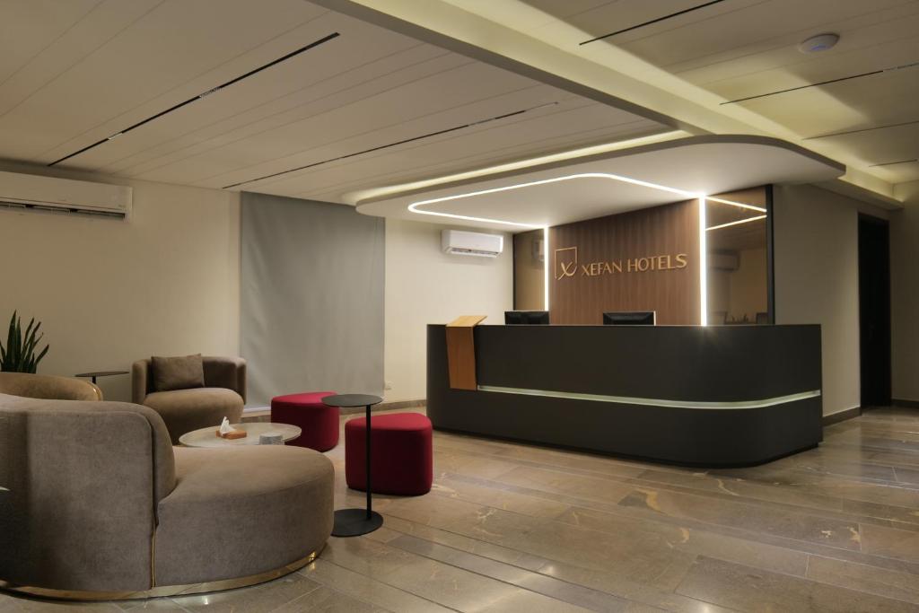 a lobby with two chairs and a reception desk at Xefan Hotels in Karachi