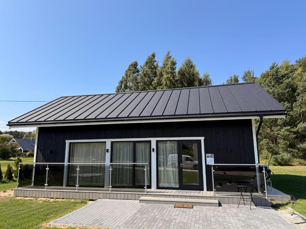 a black house with a solar roof at Meža māja in Ģipka