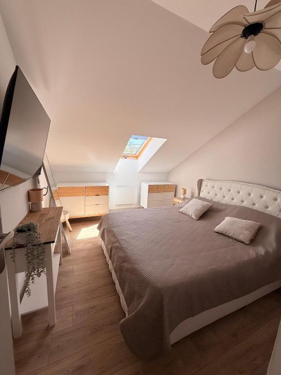 a bedroom with a bed and a ceiling fan at Appartement neuf à louer in Moyenmoutier