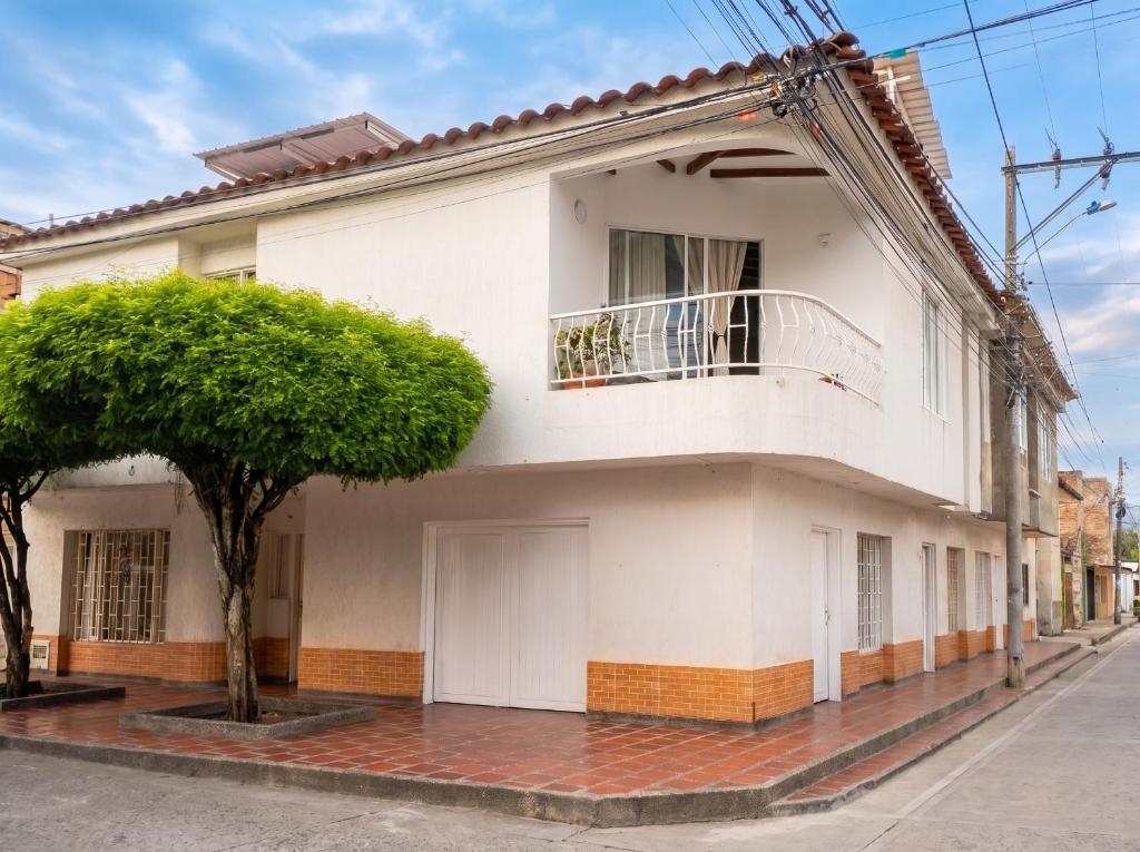 a white house with a tree in front of it at Hostal, casa Jaramillo in Roldanillo