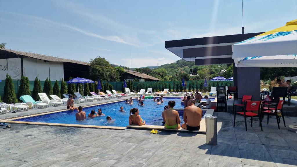 a group of people sitting in a swimming pool at Casa Maya in Săsciori