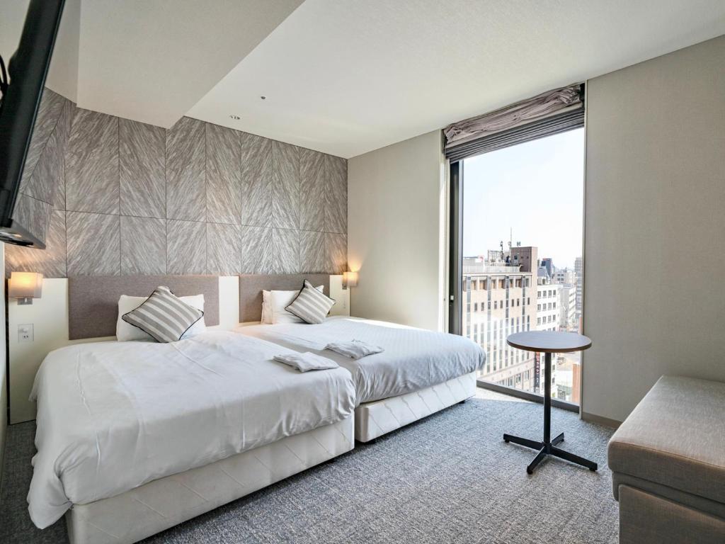 a bedroom with a large white bed and a large window at Meitetsu Inn Nagoyaeki Shinkansenguchi in Nagoya