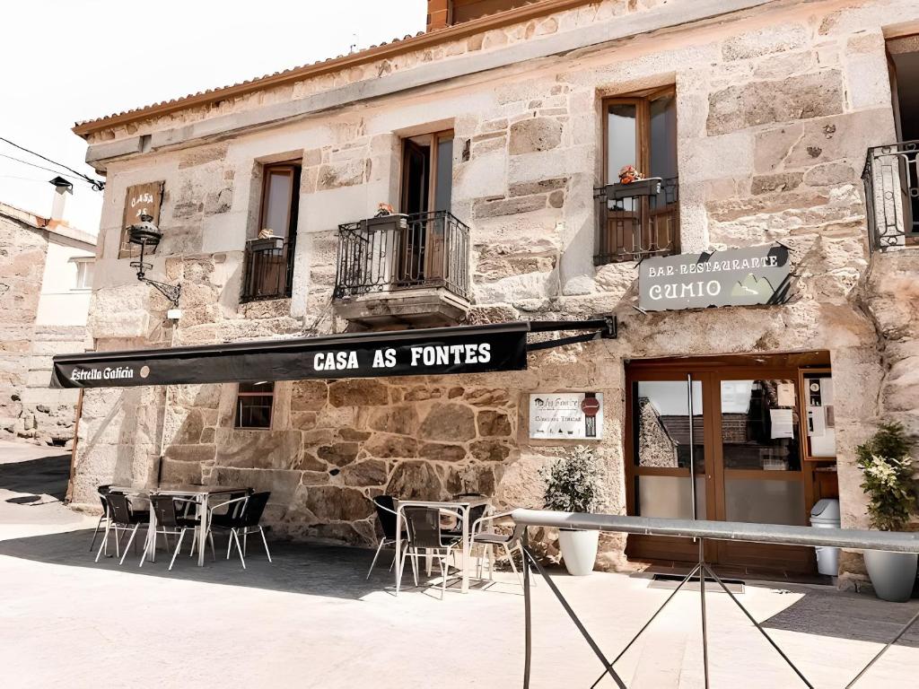 a restaurant with tables and chairs outside of a building at Casa As Fontes in Porqueirós