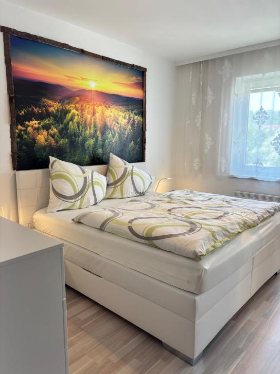 a bedroom with a bed with a painting on the wall at Appartement Landzeit im Waldviertel in Steinbach